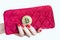 Virtual money golden bitcoin on pink women fabric purse. fingers with red nails on a coin isolated on white background