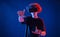 Virtual reality experience. Young man with curly hair is indoors illuminated by neon lighting