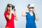 Virtual Reality Simulation. Pair of Caucasian Twin Teenager Girls Playing With VR Virtual Reality Helmets Together Indoors