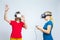 Virtual Reality Simulation. Pair of Funny and Playful Caucasian Twin Teenager Girls Playing With VR Virtual Reality Helmets