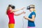 Virtual Reality Simulation. Pair of Funny and Playful Caucasian Twin Teenager Girls Playing With VR Virtual Reality Helmets