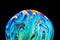 Virtual reality space with abstract multicolor psychedelic planet. Closeup Soap bubble like an alien planet on black background