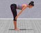 Virtual Woman in Yoga Standing Half Forward Bend Pose with a clear wood floor