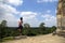 Virtual Woman in Yoga Tree Pose on a terrace of an old Angkor temple with blue sky