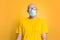 Virus protection. Against a yellow background stands a bald man in a yellow t-shirt, fogging glasses and a medical mask. Concept