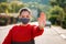 Virus protection and distance control. A young woman in a protective medical mask shows a stop sign with her palm. Outdoor.