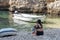 Vis, Croatia - Aug 17, 2020: Female sit on sheltered cove Stiniva beach in summer