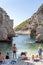 Vis, Croatia - Aug 17, 2020: Tourists sunbathing on sheltered cove Stiniva beach in summer