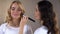 Visagiste applying evening make up on womans face, beauty tips, workshop