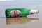 Visakhapatnam, Andhra Pradesh on 16th March in 2016 : An empty beer bottle lying down on the sand in Vizag Yarada beach.