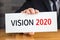 Vision 2020, message on white card and hold by