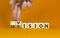 Vision and decision symbol. Businessman turns wooden cubes and changes the word `decision` to `vision`. Beautiful orange table