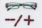 Vision glasses and capsules in form of plus and minus signs on white background