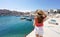 Visit Italy. Rear view of young female tourist holding hat and looking Giovinazzo harbor in Apulia, Italy