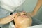 A visit to the beautician. Procedure-carboxytherapy. Doctor cosmetologist makes facial massage of the patient after the procedure