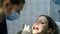 Visit to the dentist. Orthodontist doctor sets up iron braces for a woman with a dental fixator