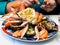 visitor eats seafood in local fish restaurant