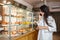 A visitor looks at a showcase of pastries in a coffee shop while talking on a mobile phone