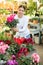 visitor to flower shop examines large flowers of cyclamen