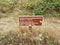 Visitors must use walking trail sign and brown grass