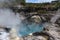 Visitors over a boiling geothermal pool. Whakarewarewa, New Zealand