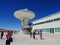 Visitors at a radiotelescope, large antenna at Alma Observatory in San Pedro de Atacama, Chile