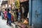 Visitors selecting and negotiating for goods along historic busy narrow street around Bhaktapur, Nepal.