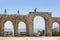 Visitors to the ancient site of Jerash in Jordan walk along the remains of the arched Hippodrome.