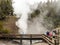 Visitors to the Yellowstone Park watching geyser from boardwalk