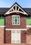 Visor on the building. Window with a wooden casement. Fragment of the building. White wooden door. Roof with metal tile