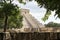 Vista de piramide entre arboles y piedras en ChichÃ©n Itza Maravilla del Mundo MÃ©xico