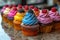 A visually appealing row of expertly decorated cupcakes sitting on top of a counter