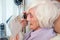 Visually impaired elderly woman with magnifying loupe