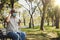 Visually impaired senior Asian man wearing mask, black glasses and walking stick. Blind man sits in a chair.