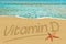 Vitamin D handwritten on the sand beach