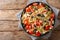 Vitamin fresh greek pasta spaghetti salad with cheese and vegetables close-up on a plate. Horizontal top view