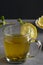 Vitamin ginger drink with honey mint and lemon in a glass cup on a concrete background