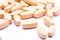 Vitamin orange pills on white background, close up