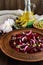 Vitamin salad of beets, green peas, blue onion in a clay bowl.