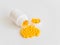 Vitamins. Antiviral drug tablets. Round yellow healthy pills and pill bottle on white background