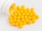 Vitamins. Antiviral drug tablets. Round yellow healthy pills and pill bottle on white background