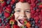 Vitamins from berrie. Mix of berries. Kids face with fresh berries fruits. Assorted mix of berries strawberry, blueberry