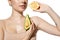 Vitamins. Close up of beautiful young woman with avocado and orange halfs over white background. Cosmetics and makeup