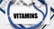 Vitamins word on white paper on calendar sheets, banner, top view. health concept