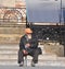 VITEBSK, BELARUS - MAY 17, 2017: Elderly man in shabby clothes sits on stone steps