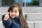 Vivacious little girl giving a thumbs up gesture