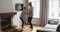 Vivacious senior spouses dancing together in cozy living room