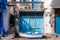 Vivid blue garage doors with a small wooden boat in front in Greek Klima fishermen village - the most colorful village in Greece