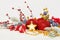 Vivid Christmas composition with baubles, holly berries, Xmas fir tree twig and golden garland on white snow background