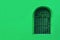 Vivid green outer wall with wrought iron vintage window